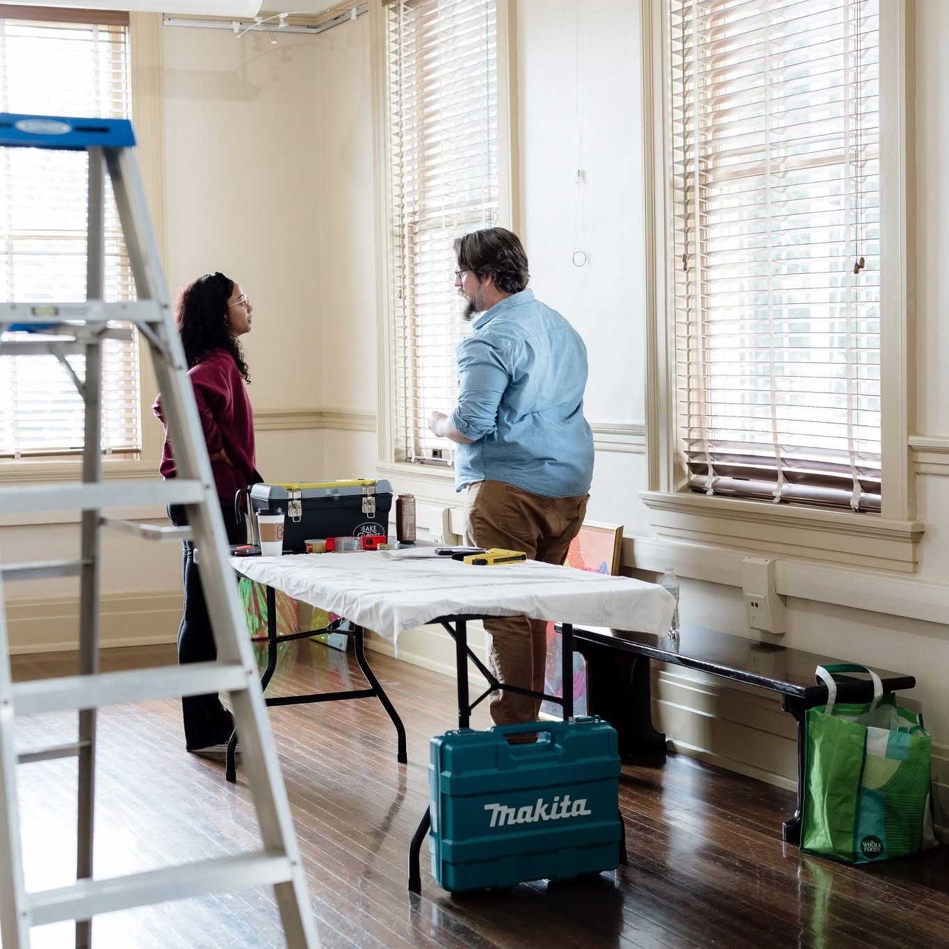 Jasmine Patterson speaking with a person while preparing artwork inside Black Heritage Gallery
