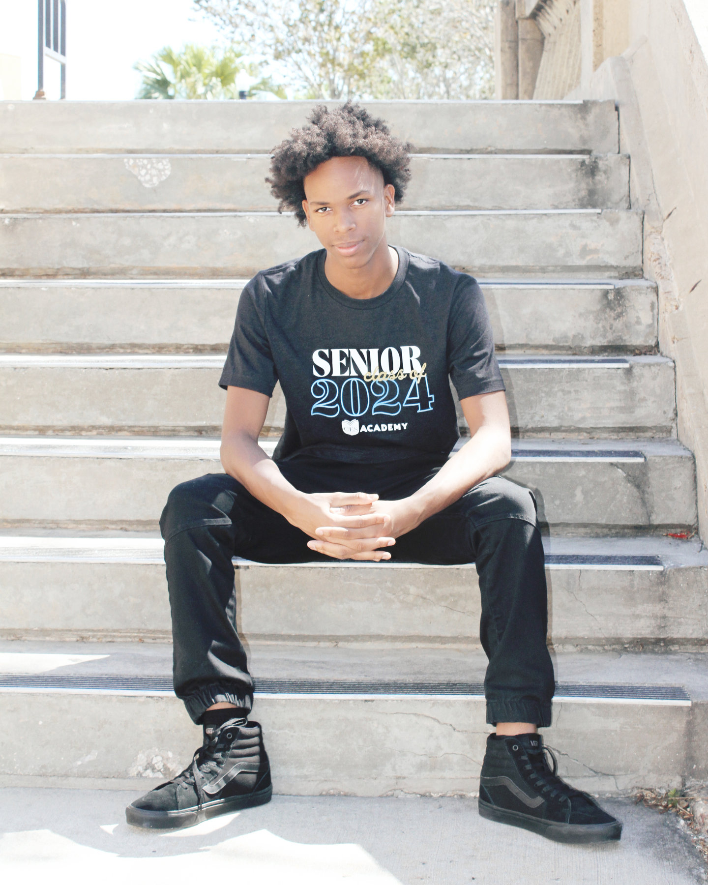Teen in a Senior t-shirt seated on outdoor stone steps