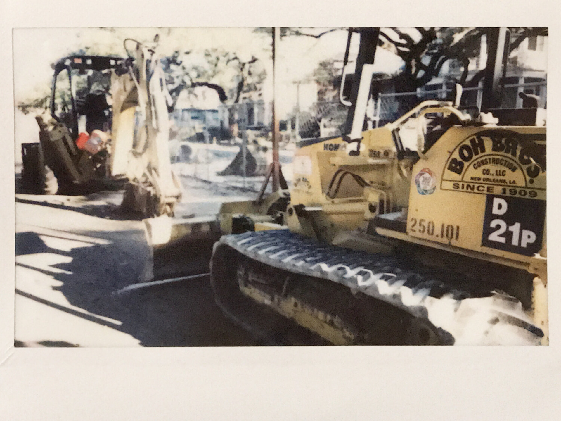 Instant film photo of a snow-dusted bulldozer on a New Orleans street