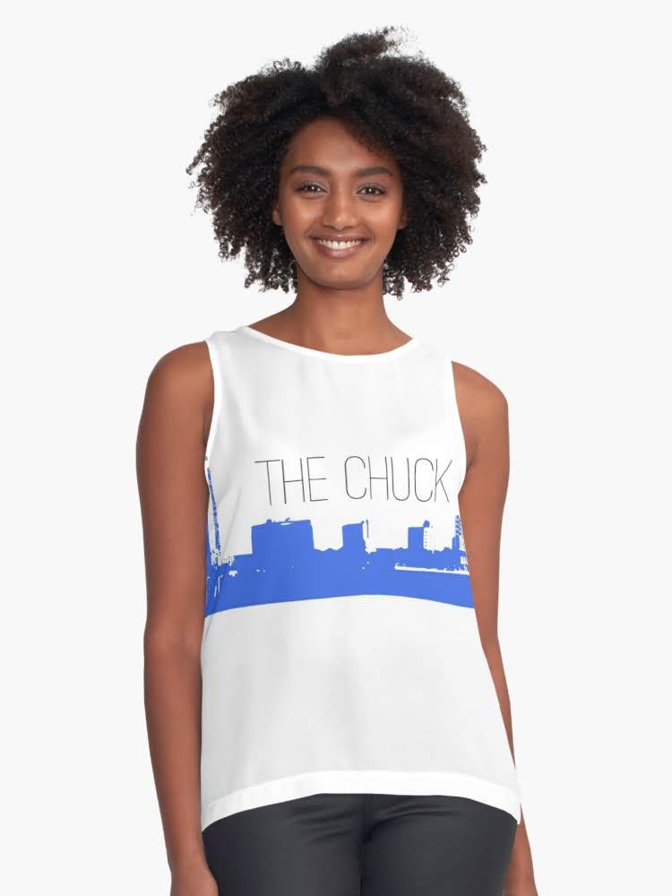Woman wearing a white THE CHUCK tank top with a city skyline graphic