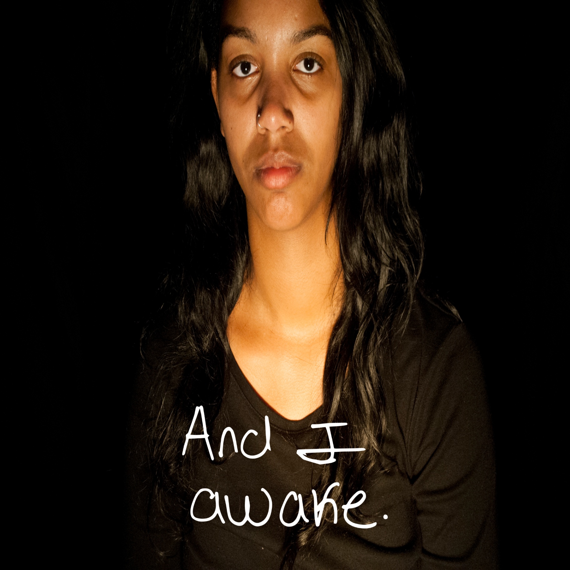 Blurred self-portrait against a black background with handwritten text: And I awake.