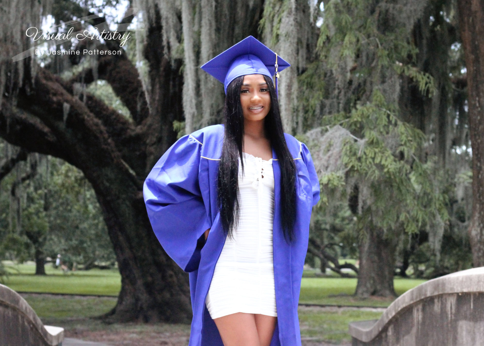 Graduate in a blue gown and cap over a white dress, portrait