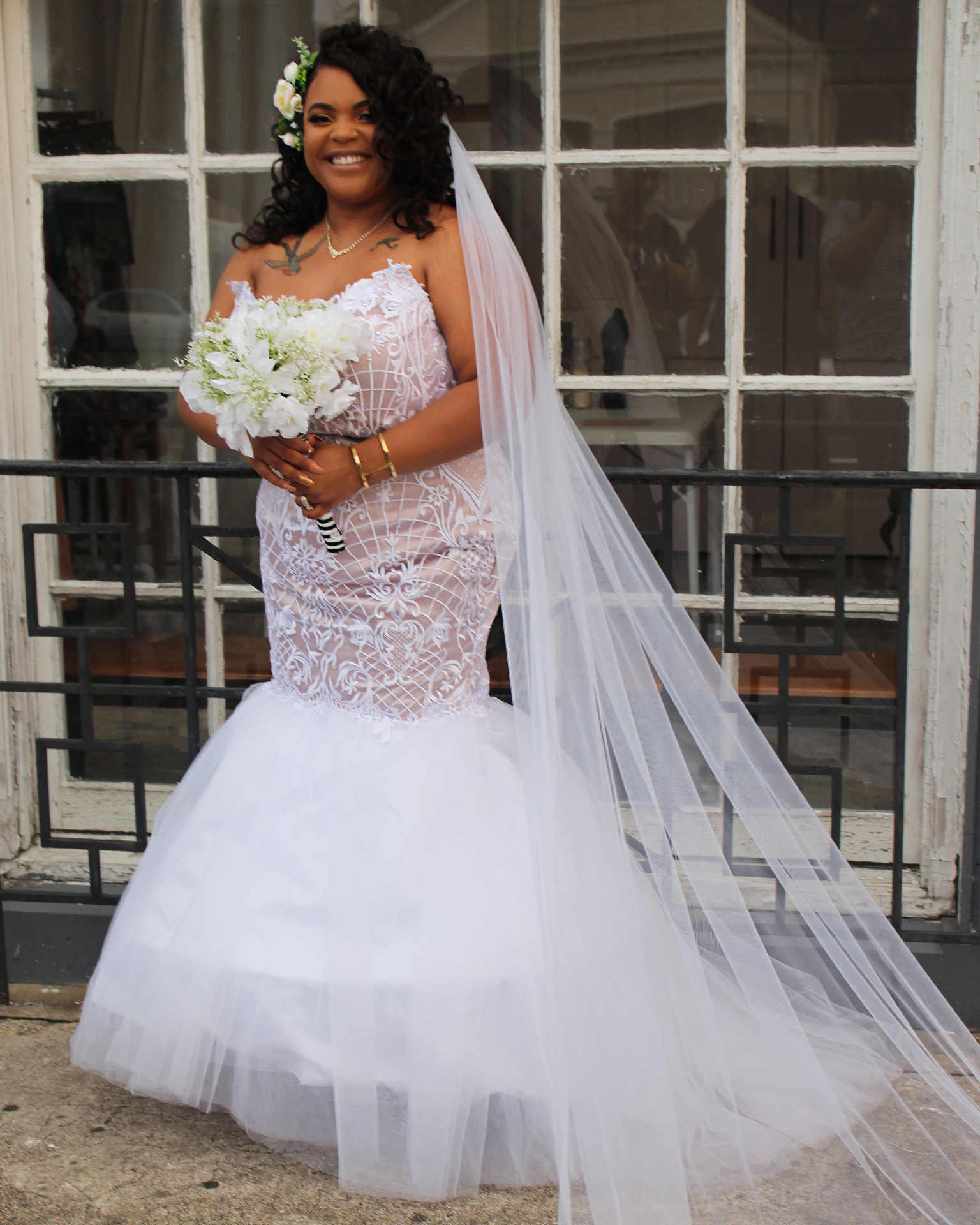 Bride laughing with her bouquet, veil sweeping the ground