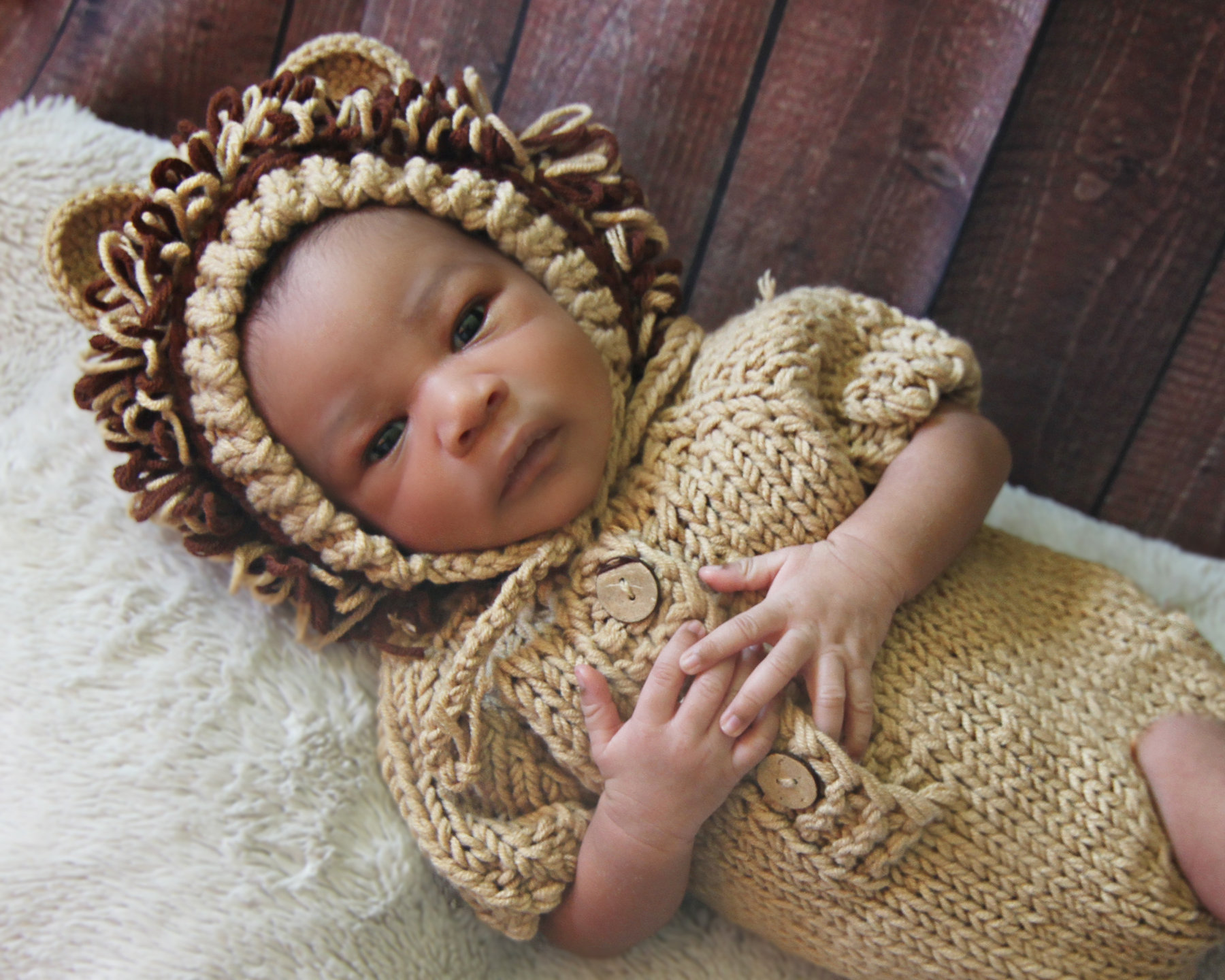 Newborn wearing a knitted lion hat