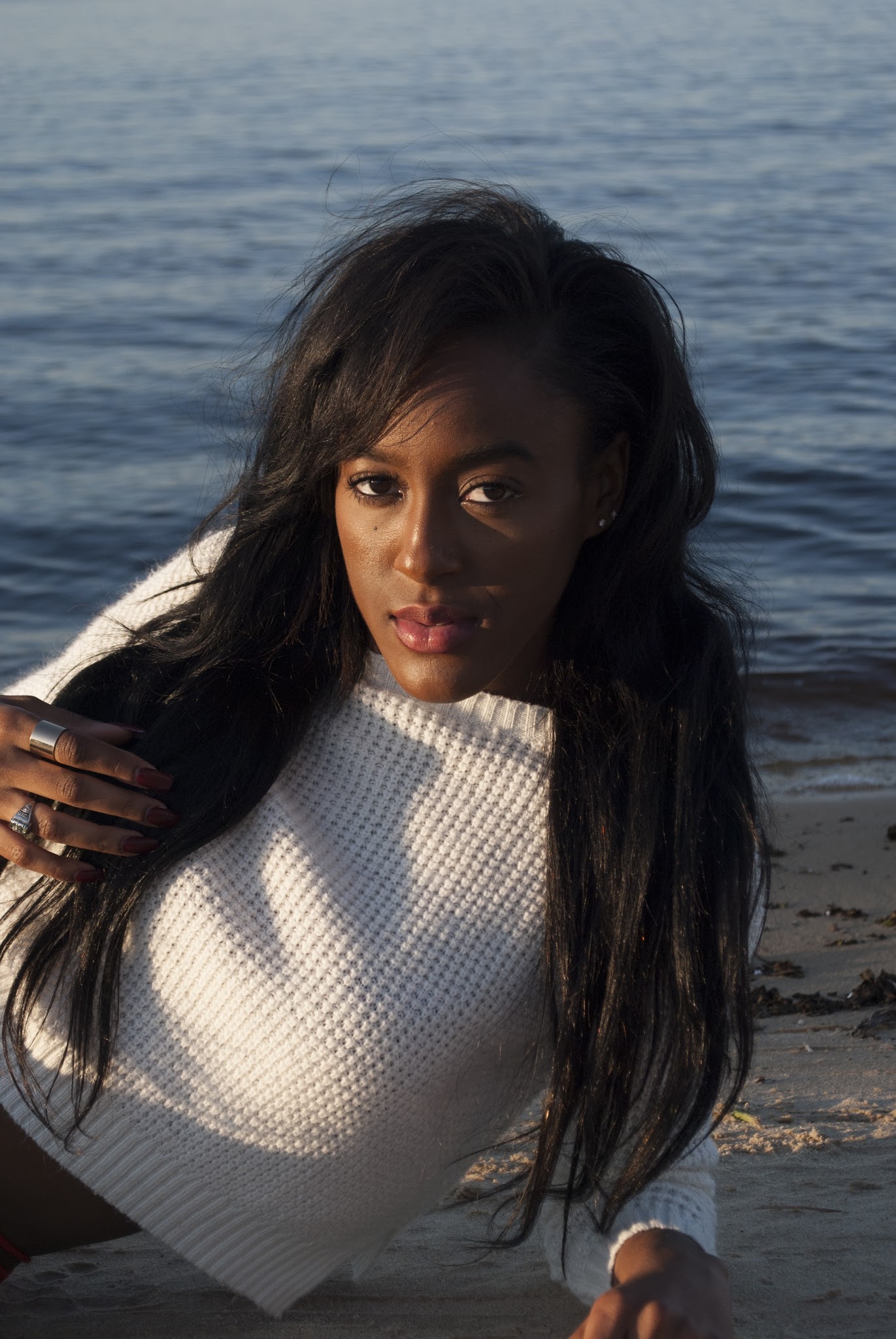 Portrait of a woman in a white sweater by the water