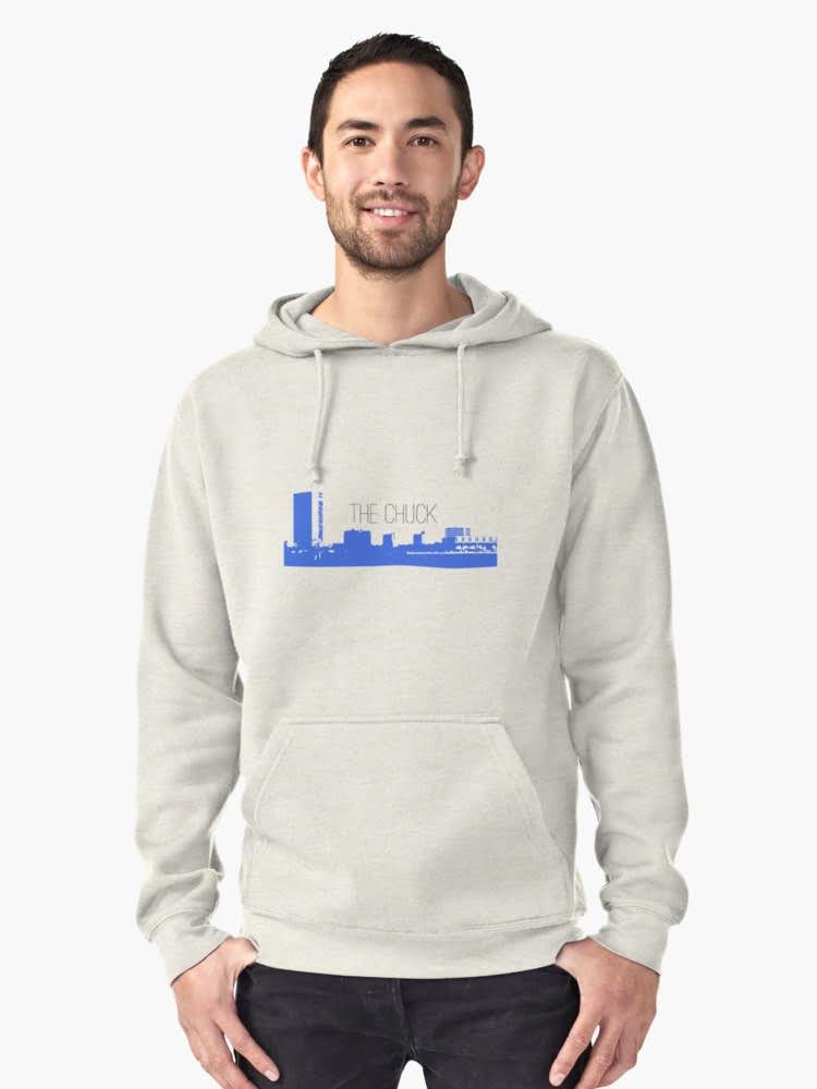Man wearing a grey THE CHUCK hoodie with a city skyline graphic