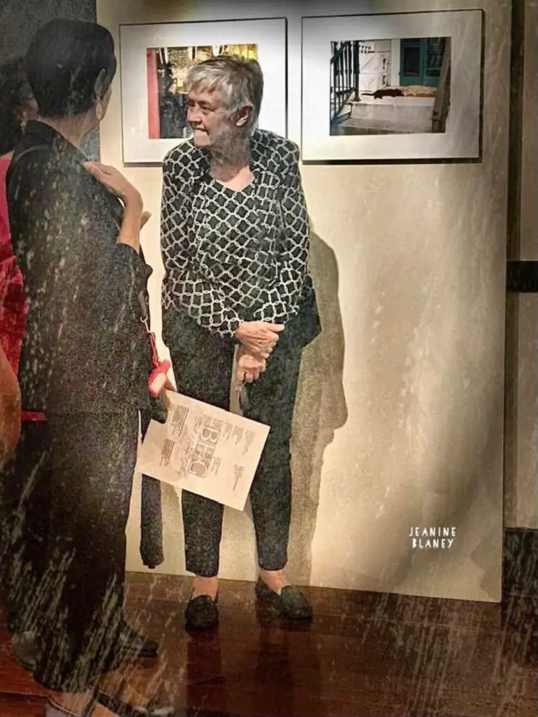 Two visitors talking in front of Jasmine Patterson's framed photographs at Black Heritage Gallery