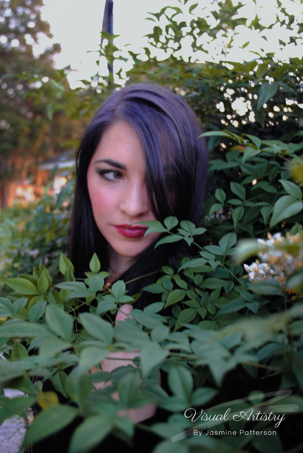 Woman partly hidden behind green leaves