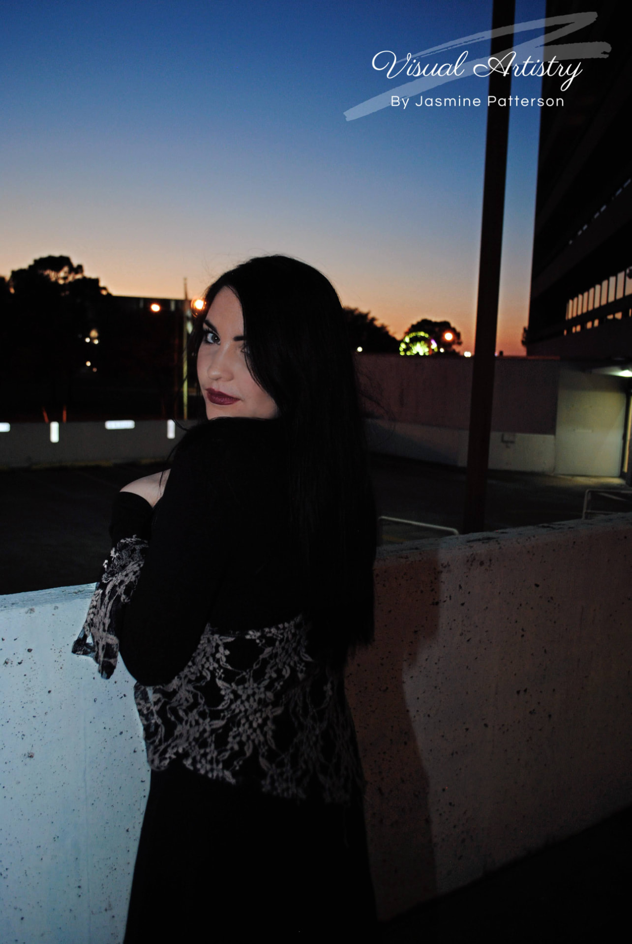 Woman in black and lace looking back at dusk on a rooftop