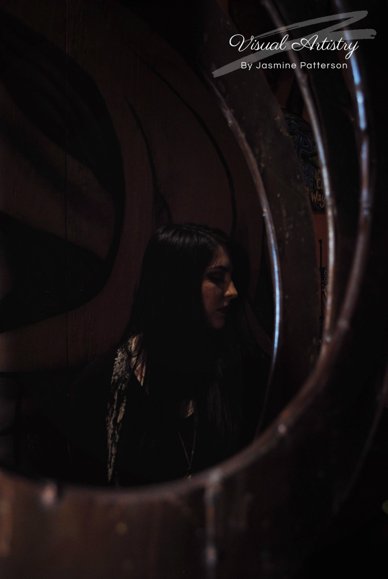Woman in shadow framed by curved rusted metal
