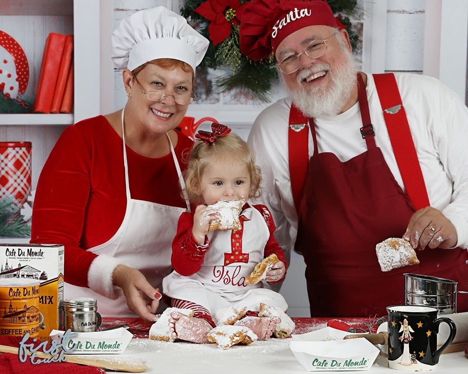 Child sharing a baking set with Santa and Mrs. Claus