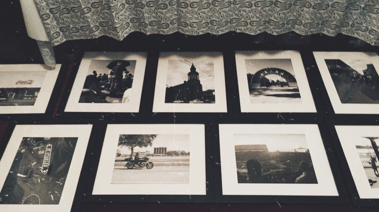 Framed black-and-white photographs laid out on the floor before exhibition