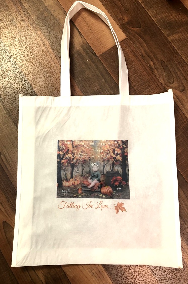 Tote bag printed with the Falling In Love artwork, hanging against a white wall