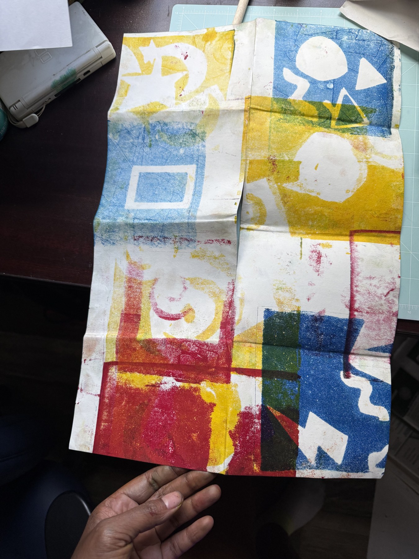 Grid of colorful monoprint squares in red, yellow, blue, and green