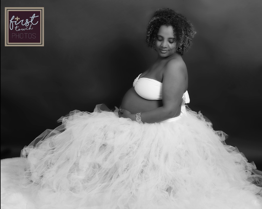 Black-and-white studio maternity portrait with a flowing tulle skirt