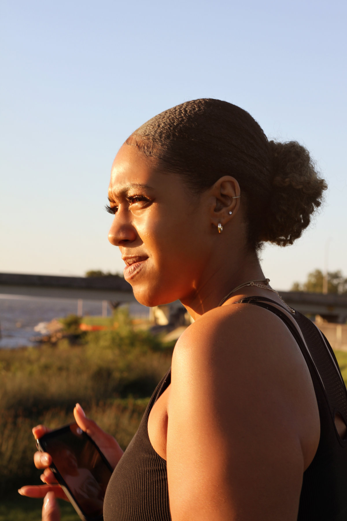 Woman in profile in warm evening light by the water
