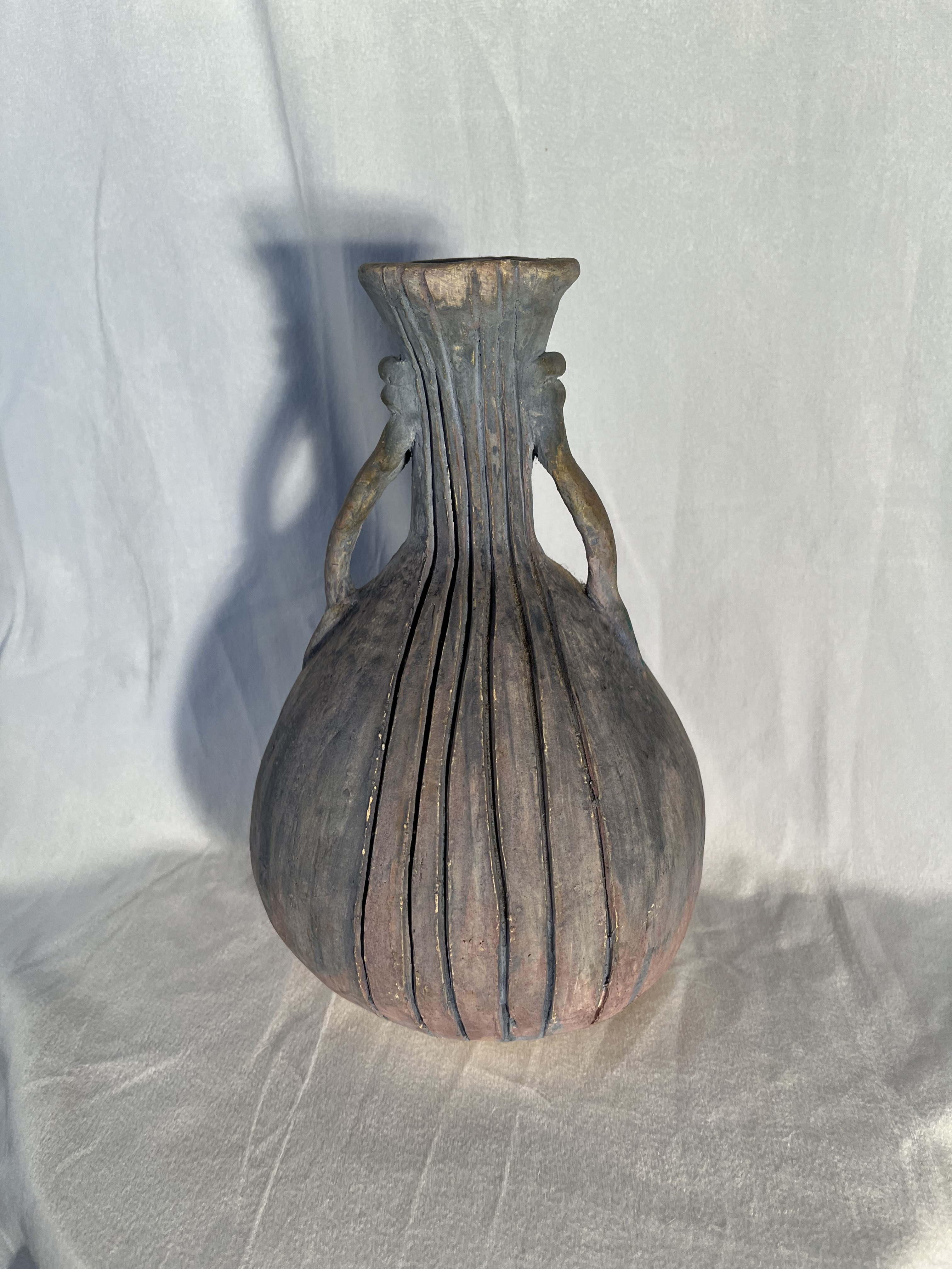 Tall striped ceramic vessel with a narrow neck and folded rim