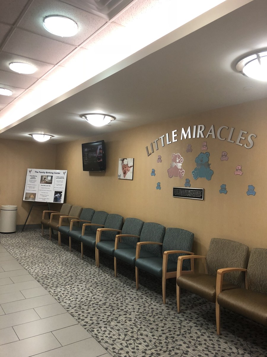 Framed newborn and maternity prints arranged in the Little Miracles waiting room at Ochsner Hospital in New Orleans
